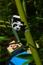 LEGO Minecraft action figure of Steve climbing on main stalk of bamboo plant, small lego Panda bear observing him.