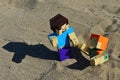 LEGO Minecraft action figure of Steve pulling his female friend Alex from shifty sand pit on a beach. Summer afternoon sunshine.