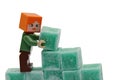 LEGO Minecraft figure of Alex is building a wall from green coloured scented stearine wax cubes Royalty Free Stock Photo