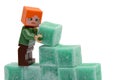 LEGO Minecraft figure of Alex is building a wall from green coloured scented stearine wax cubes, possibly of mint flavor Royalty Free Stock Photo