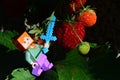 LEGO Minecraft figure of Alex with diamond sword ready to cut some fresh red mature strawberries in garden.