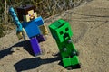LEGO Minecraft figure of Steve with diamond sword ready to surprise hostile explosive green Creeper mob from behind