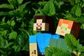 LEGO Minecraft figures of Steve and Alex standing in dense foliage of Lemon Balm Melissa Officinalis and Spearmint. Royalty Free Stock Photo