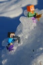LEGO Minecraft figures of Steve with iron pickaxe and Alex with golden sword climbing on glacier mountain