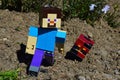 LEGO Minecraft large figure of Steve is escapes from dangerous hostile Nether mob Magma Cube on spring sunlit garden soil