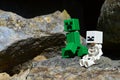 LEGO Minecraft monster mobs, Skeleton and Creeper, sitting in front of mountain cave.