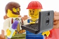 Lego minifigures of builder and supervisor with laptop
