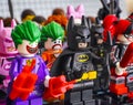 Lego minifigures standing in rows. In first row - The Joker, Batman, Harley Quinn. Focus on the Batman