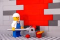 Lego painter minifigure painting a wall red. Close-up Royalty Free Stock Photo