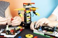 Lego robot. A child and a woman assemble a robot from plastic parts, train. The hottest gadgets. E-learning. Modern training