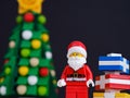 Lego Santa Claus minifigure with presents near him standing near a christmas tree Royalty Free Stock Photo