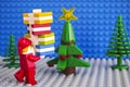 Lego Santa Claus with stack of presents near christmas tree