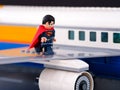 A Lego Superman minifigure standing on the wing of a passenger airplane Royalty Free Stock Photo