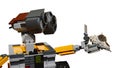 LEGO Wall-E robot from Disney Pixar movie carrying seashell of Fasciolariidae or Triplofusus family in his left arm.