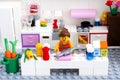 Lego woman cooking fish in domestic kitchen