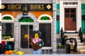 Lego woman minifigure with book stands near Birch Books building