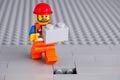 Lego worker minifigure with gray brick finishing building wall Royalty Free Stock Photo