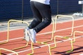 Legs of athlete jumping over small plastic hurdles on a track Royalty Free Stock Photo