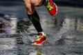 legs athlete runner in compression socks running puddle on road