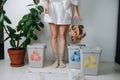 Legs of a woman throwing piece of crampled packing paper in a small recycle bin Royalty Free Stock Photo