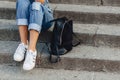 Legs and bag young pretty girl with briefcase sitting on stairs