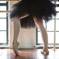 Legs of a ballerina closeup. The legs of a ballerina in old pointe. Rehearsal ballerina in the hall. Contour light from the window Royalty Free Stock Photo