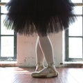 Legs of a ballerina closeup. The legs of a ballerina in old pointe. Rehearsal ballerina in the hall. Contour light from the window Royalty Free Stock Photo