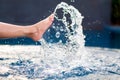 Legs and bare feet kicking and splashing water in the pool