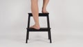 Legs and Barefoot is step up on step stool or wooden stairs on white background