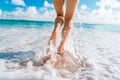 Legs of a beautiful young girl who runs towards the ocean on a sandy beach. Vacation on the Paradise beaches of Asia. Summer and Royalty Free Stock Photo