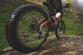 Legs of bicyclist and rear wheel close-up view of back mtb bike in mountains against background of rocks in foggy Royalty Free Stock Photo