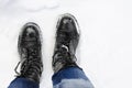 Legs in black winter boots stand on the snow. A man walks along a snowy road. Close-up. Place for text, copyspace Royalty Free Stock Photo