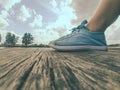 Legs in blue moccasins on a wooden dock