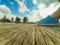 Legs in blue moccasins on a wooden dock