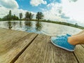 Legs in blue moccasins on a wooden dock