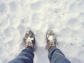 Legs of boy in light winter shoes on the snow in the snow