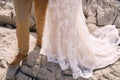 Legs of the bride and groom standing on the rock. Close-up Royalty Free Stock Photo