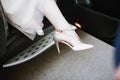 The legs of the bride in a wedding dress in shoes Royalty Free Stock Photo