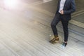 Legs of businessman wear black suit walking stepping up stair in modern city, business grow up and success concept Royalty Free Stock Photo