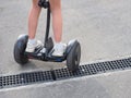 Legs of a child in white sneakers riding on a black gyroscurer