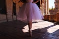 Legs of a classical ballet dancer in which she is standing on tiptoe with her hands on her hips. Classical ballet