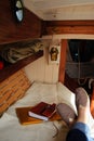 Legs with a closed computer, notebook, and pen on a wooden boat a concept of remote working