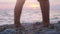 Legs of couple in love during the date near the sea on the beach during beautiful sunset. Close up Royalty Free Stock Photo