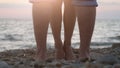 Legs of couple in love during the date near the sea on the beach during beautiful sunset. Royalty Free Stock Photo