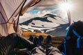 Legs of couple traveler relaxing inside a tent with volcanic mountain on geothermal area in Icelandic Highlands on summer