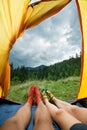 Legs of a couples of man and woman in a tent outdoors