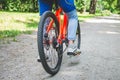 Legs of a cyclist and part of a bicycle on a dirt road