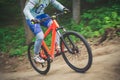 Legs of a cyclist and part of a bicycle on a dirt road, motion blur