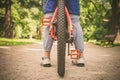 The legs of a cyclist and part of a bicycle on a dirt road, toned