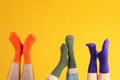 Legs in different socks on yellow background Royalty Free Stock Photo